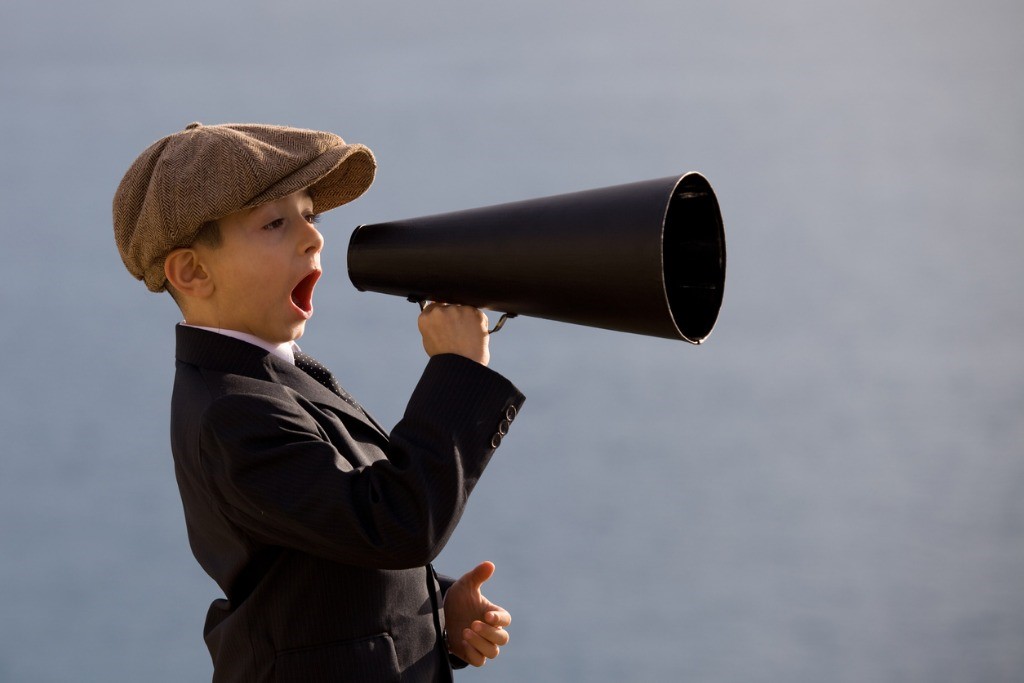 little-boy-wearing-flat-cap-shouting-on-old-fashioned-megaphone-picture-id154926743